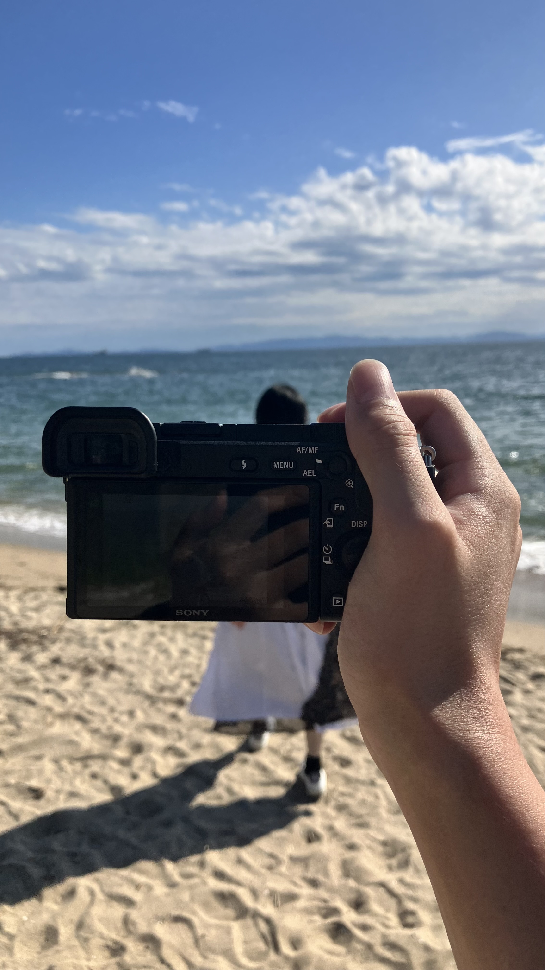 海辺でカメラを構える手元